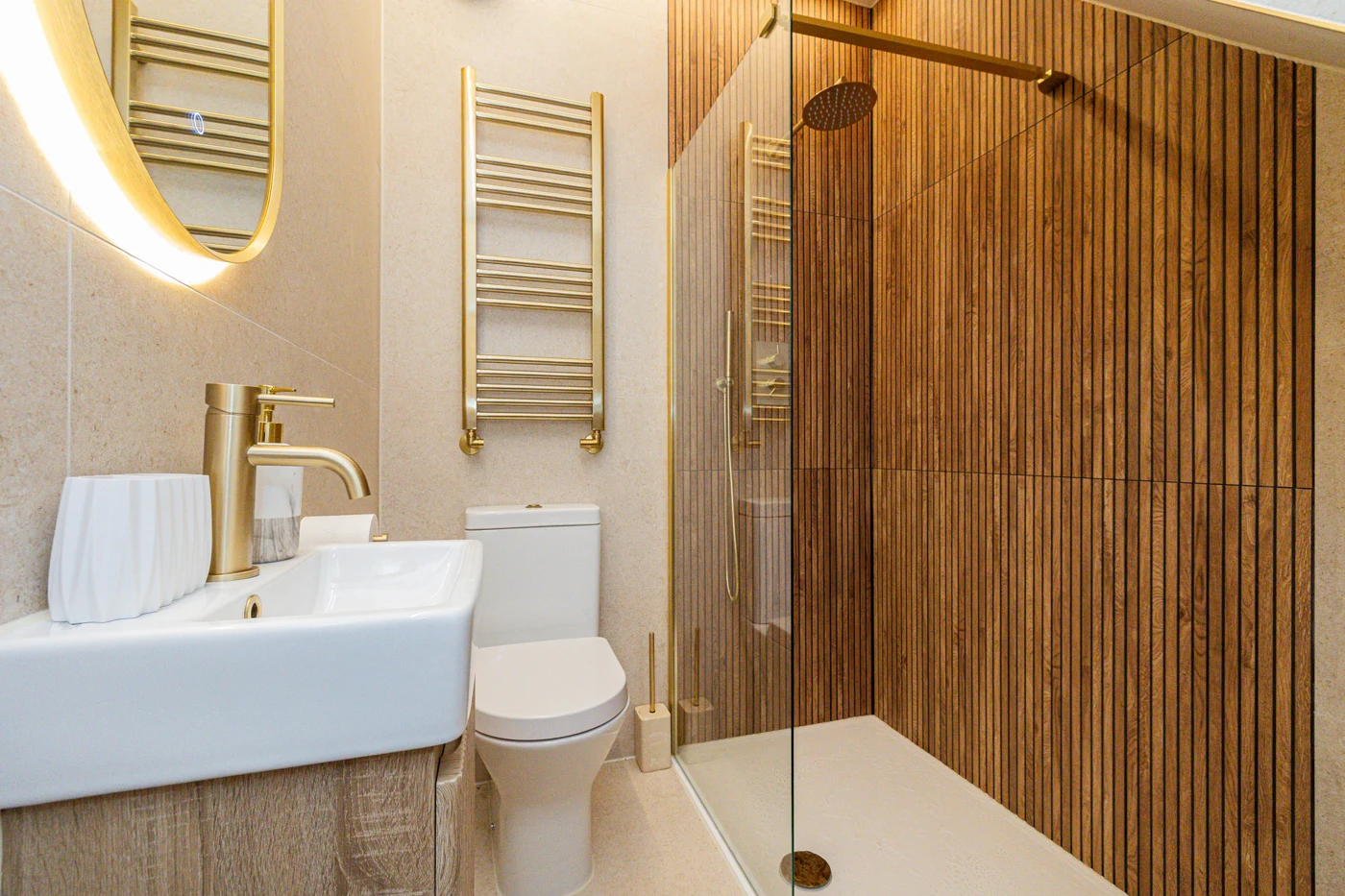 A modern bathroom with timber-effect shower walls and warm lighting